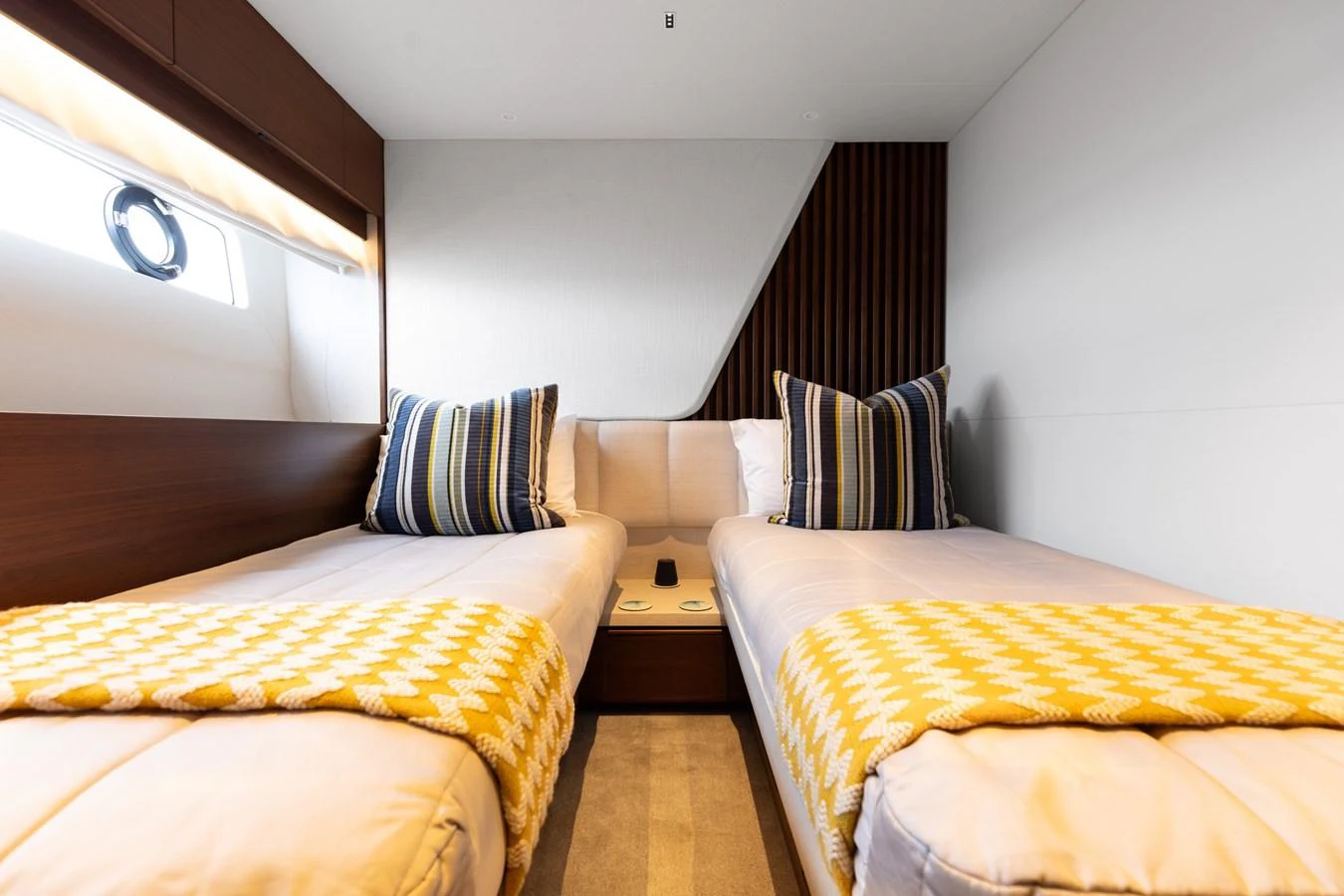 The guest stateroom features twin beds with stylish bedding and modern decor. aboard TOMORROW NEVER KNOWS Yacht for Sale