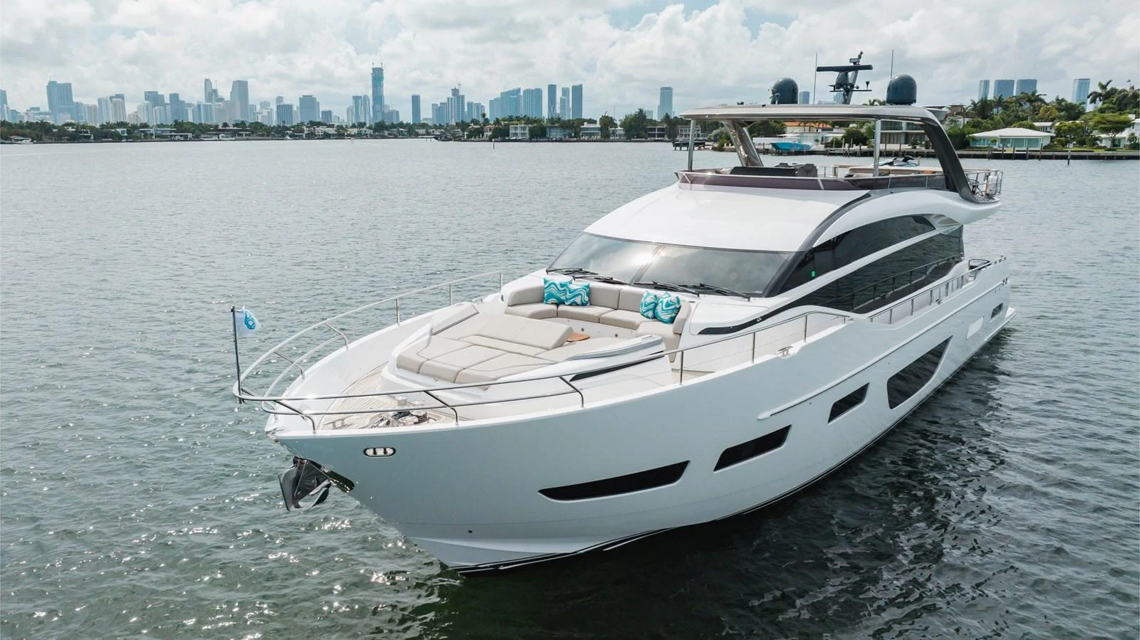 A sleek and modern yacht cruising on calm waters with a city skyline in the background. aboard TOMORROW NEVER KNOWS Yacht for Sale