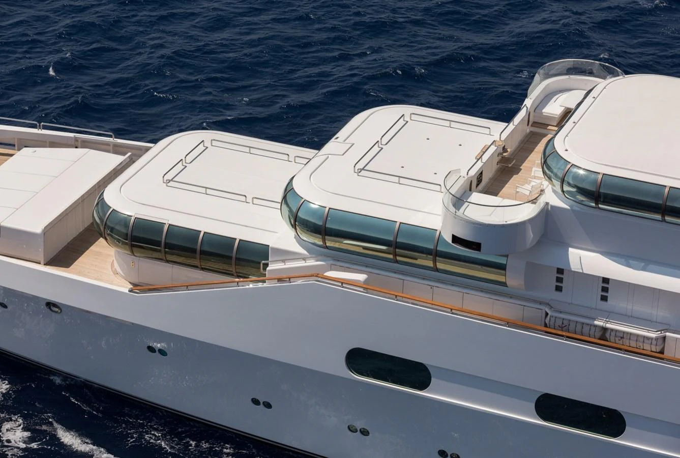 A sleek and modern yacht with expansive deck spaces and elegant design lines cruising on the open sea. aboard ZEUS Yacht for Sale