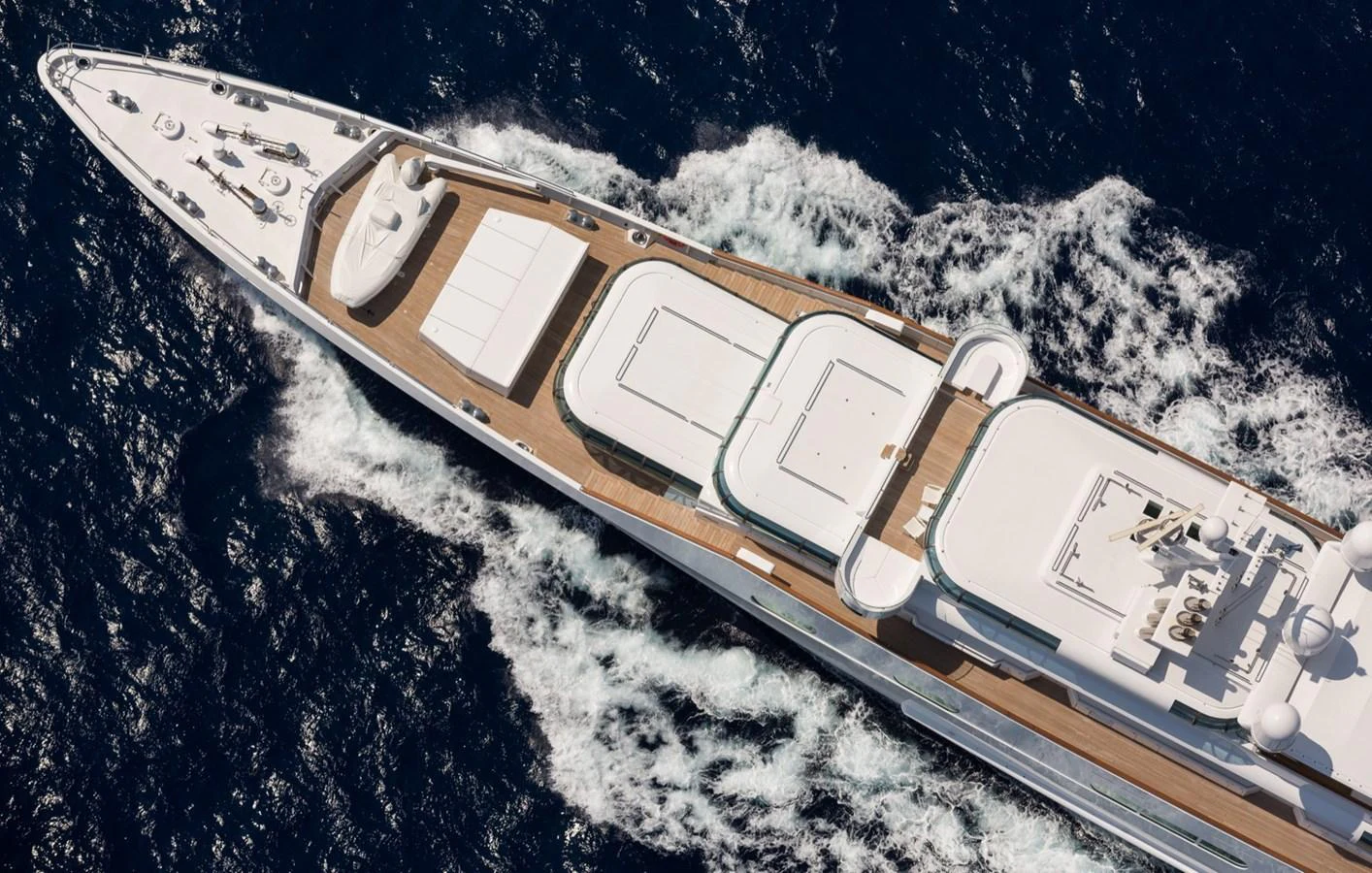 An aerial view showcases the sleek design and expansive deck space of this luxurious yacht cruising through the water. aboard ZEUS Yacht for Sale