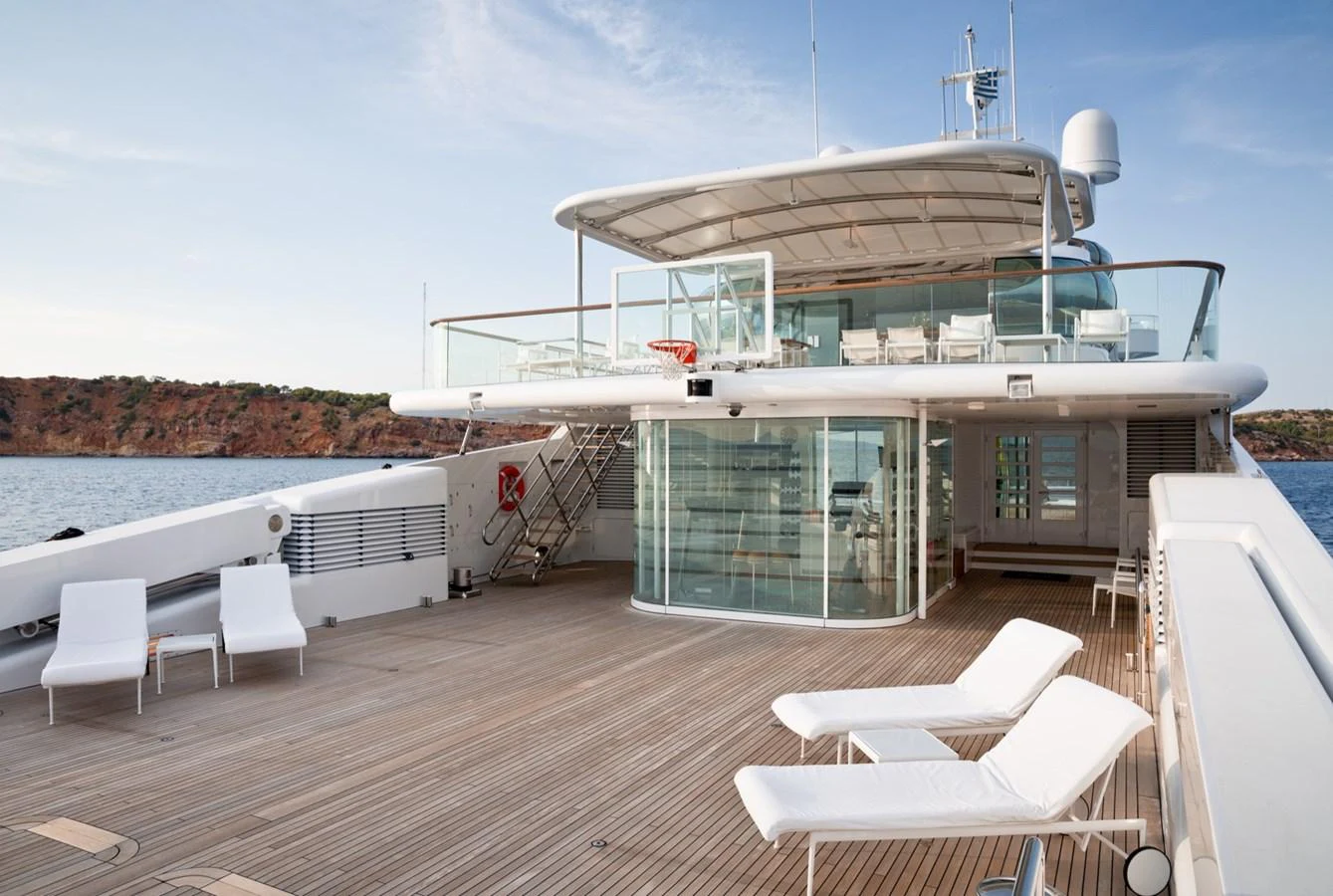 The yacht's sundeck offers a spacious area with sun loungers and a glass-enclosed lounge, perfect for relaxation and enjoying the view. aboard ZEUS Yacht for Sale