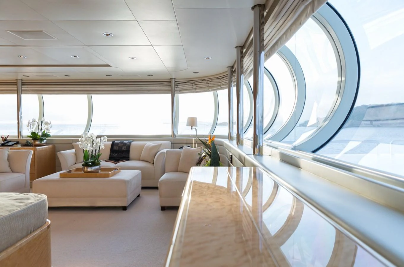 The yacht's salon features plush seating and large windows, creating a bright and inviting space. aboard ZEUS Yacht for Sale