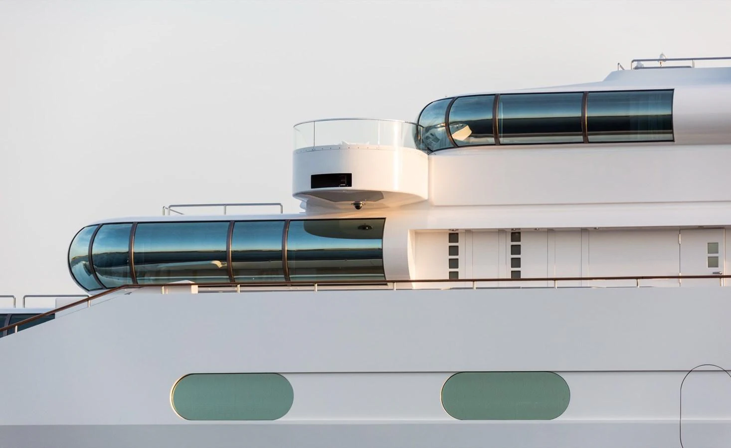The yacht features sleek, modern lines with large, curved glass windows. aboard ZEUS Yacht for Sale