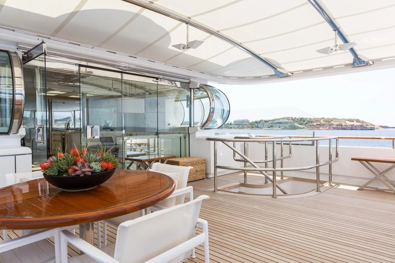The aft deck features a stylish dining area with a wooden table and comfortable seating, offering a perfect spot for al fresco meals with a view. aboard ZEUS Yacht for Sale