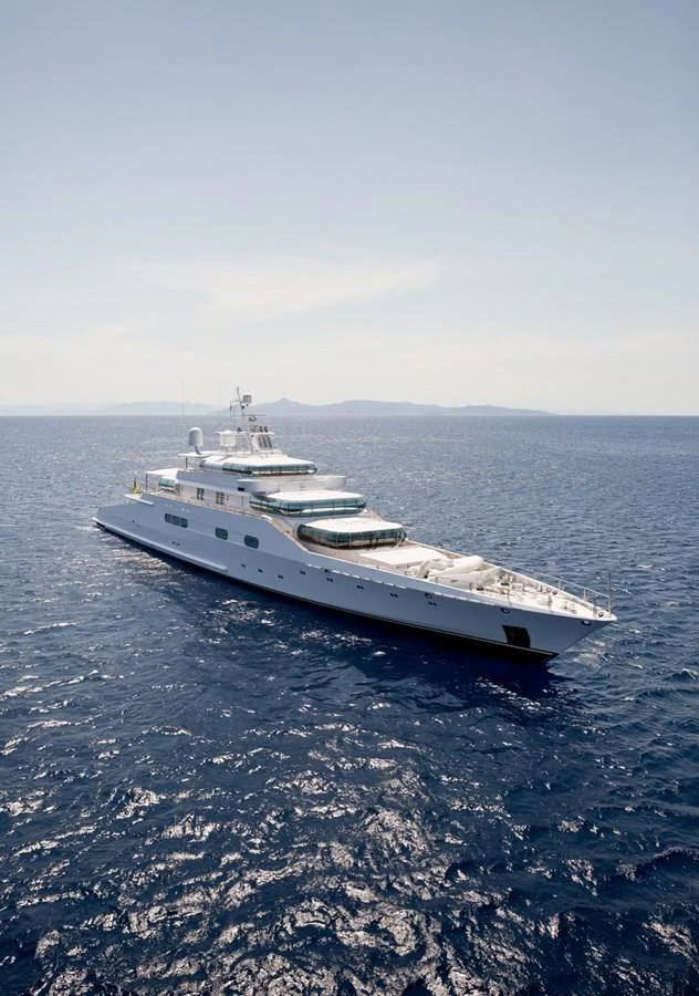 A sleek and elegant yacht glides gracefully on the open sea under a clear sky. aboard ZEUS Yacht for Sale