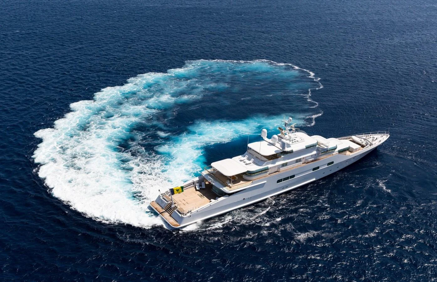 A luxurious yacht cruises through the open sea, leaving a beautiful wake behind. aboard ZEUS Yacht for Sale