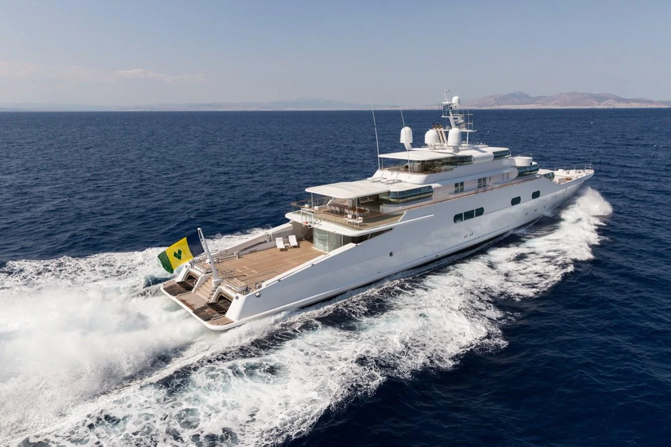 A luxurious yacht glides smoothly over the open sea, showcasing its elegant design and spacious deck. aboard ZEUS Yacht for Sale