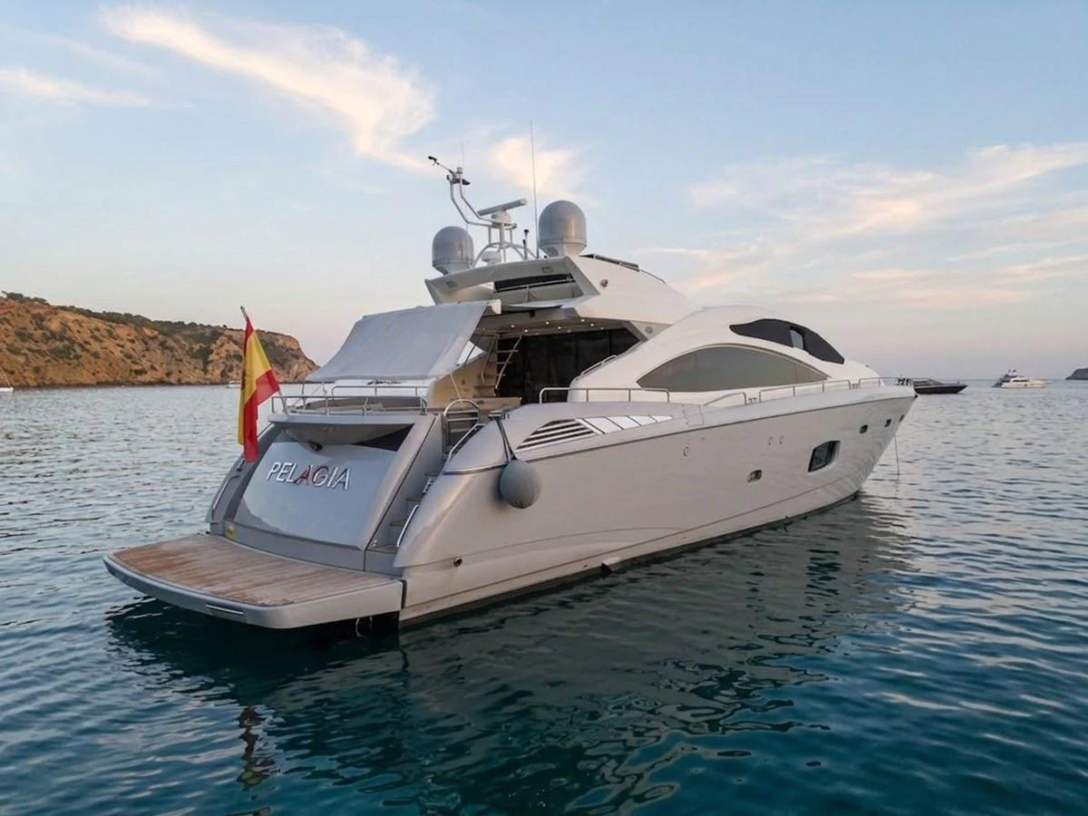 A sleek and modern yacht anchored in calm waters during sunset. aboard PELAGIA Yacht for Sale