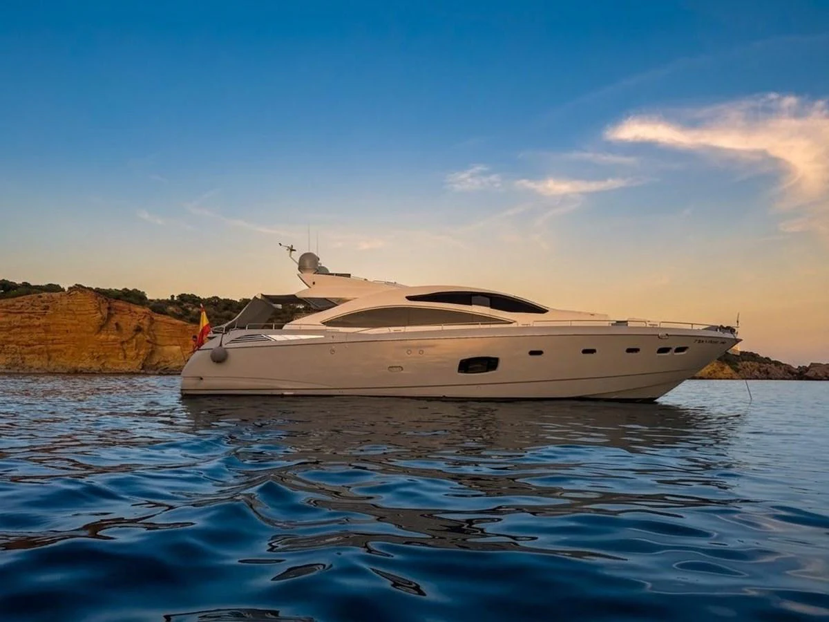A sleek and modern yacht glides gracefully on calm waters against a picturesque coastal backdrop. aboard PELAGIA Yacht for Sale