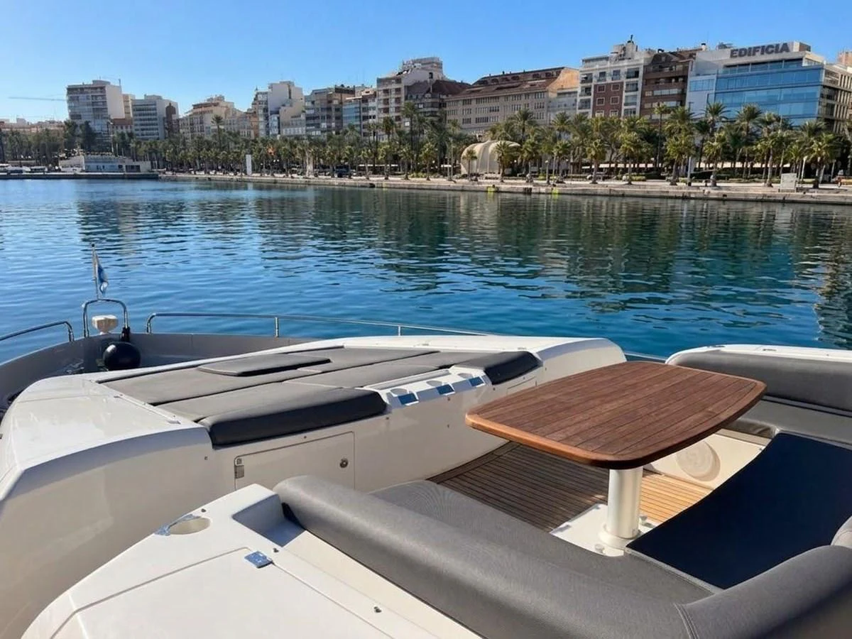 The yacht's aft deck offers a comfortable seating area with a wooden table, perfect for enjoying the waterfront views. aboard PELAGIA Yacht for Sale