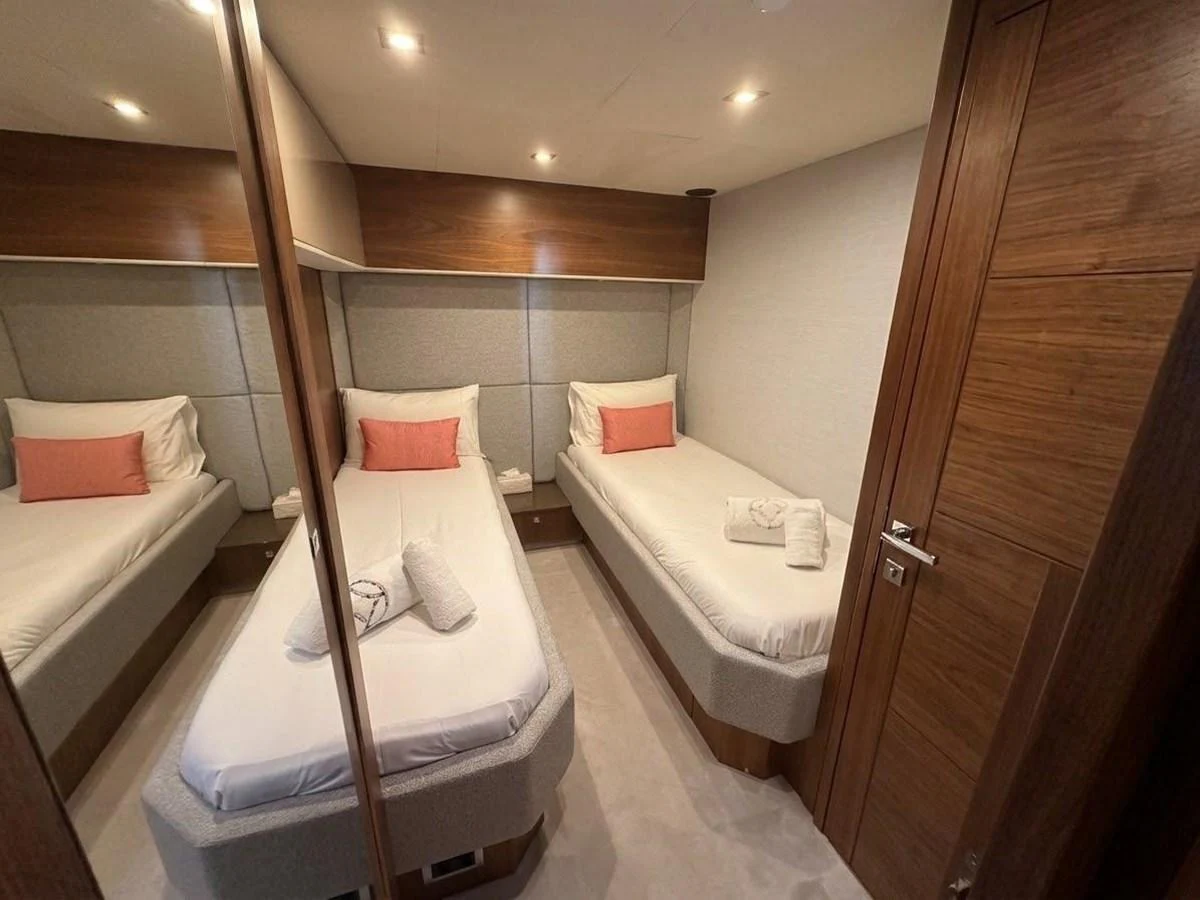 The guest stateroom features twin beds with plush bedding and warm wood accents. aboard PELAGIA Yacht for Sale