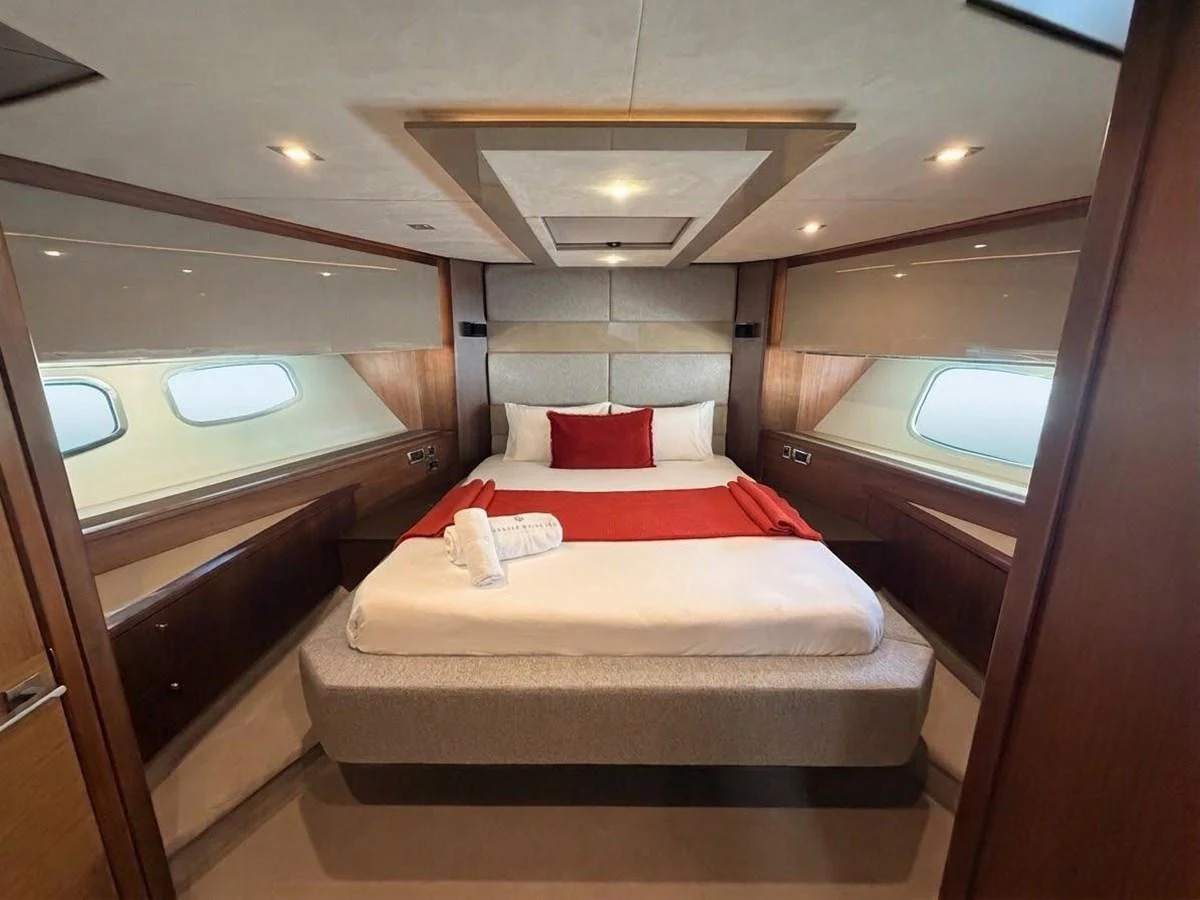 The master stateroom features a luxurious bed with elegant bedding and ample natural light from the side windows. aboard PELAGIA Yacht for Sale