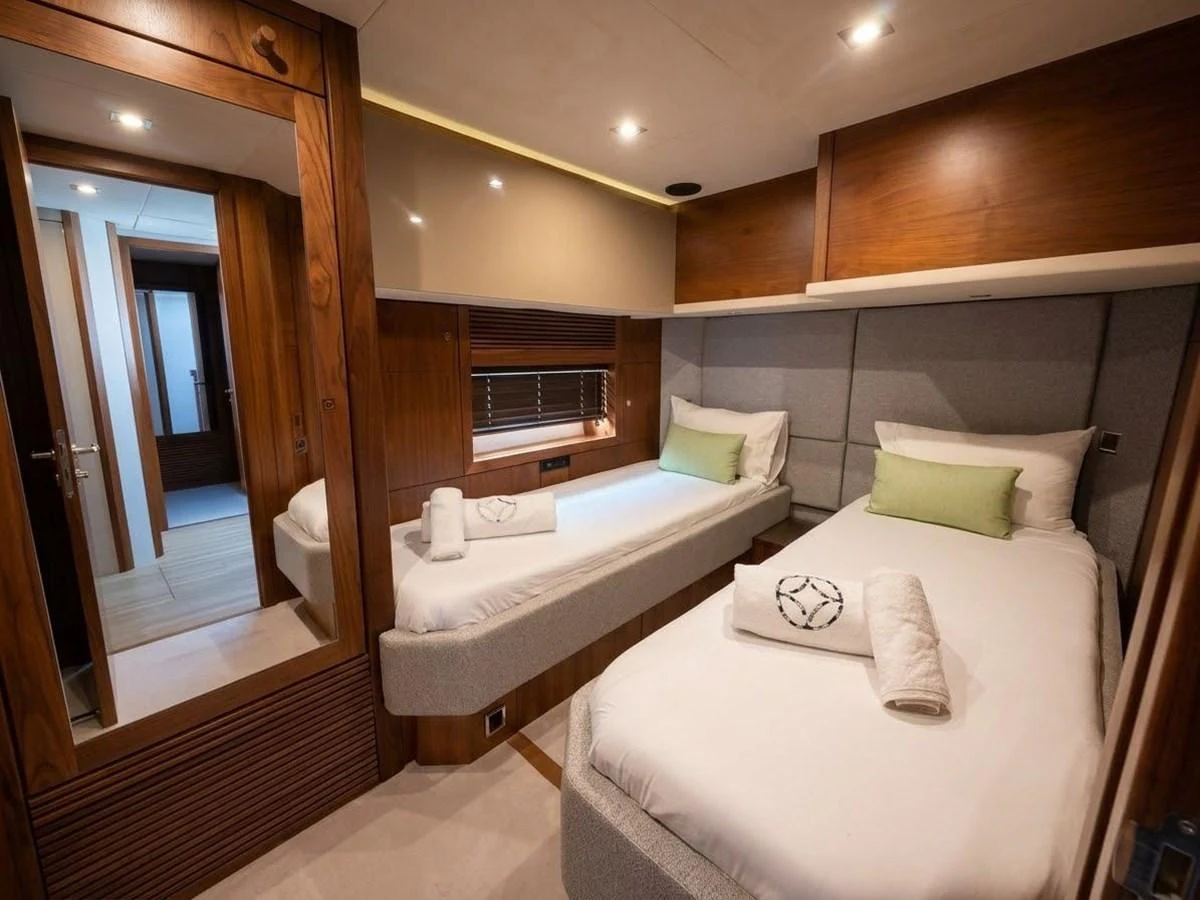 The twin stateroom offers a cozy and elegant retreat with two single beds and warm wood accents. aboard PELAGIA Yacht for Sale