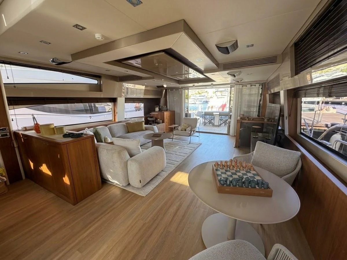 The salon offers a spacious and elegantly furnished area with ample seating and a view of the marina. aboard PELAGIA Yacht for Sale