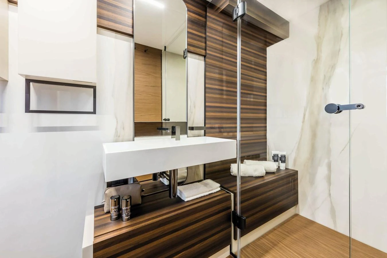 The yacht's bathroom features a sleek, modern design with wood accents and a spacious layout. aboard LIVI B Yacht for Sale