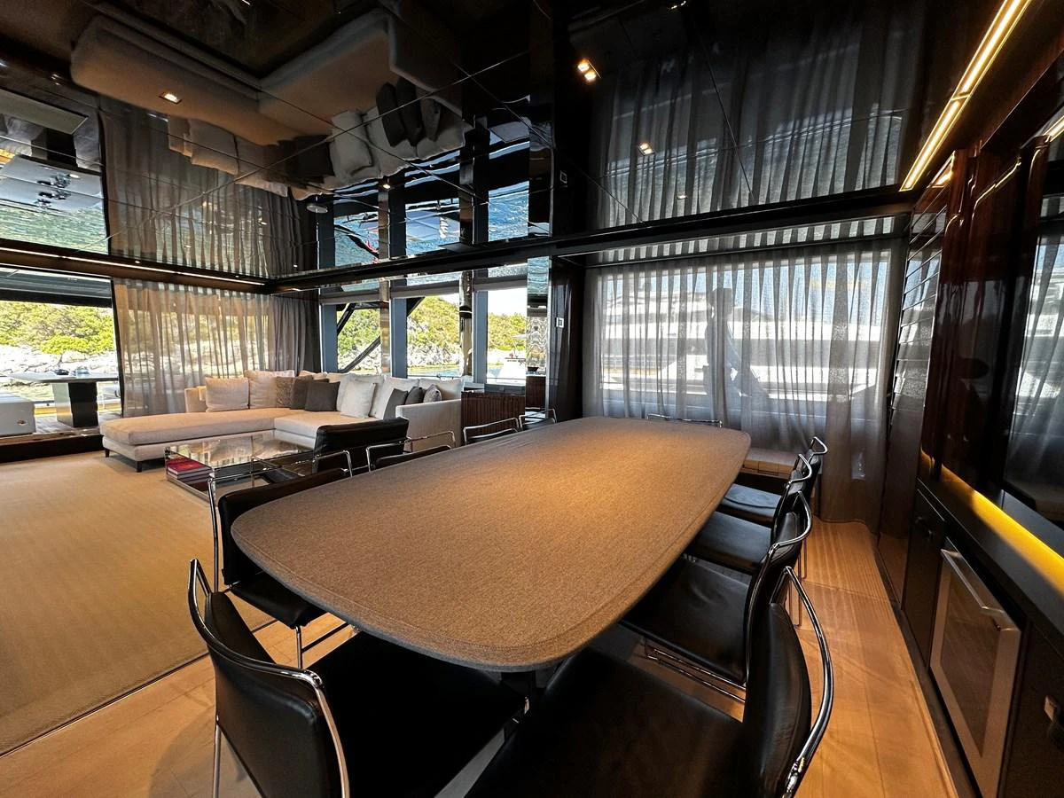 The salon features a spacious seating area with a large dining table and modern decor. aboard 4SEAS Yacht for Sale