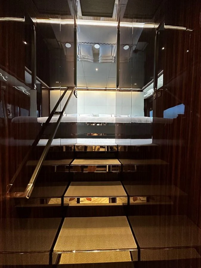 A luxurious staircase with reflective surfaces leading to an upper deck. aboard 4SEAS Yacht for Sale
