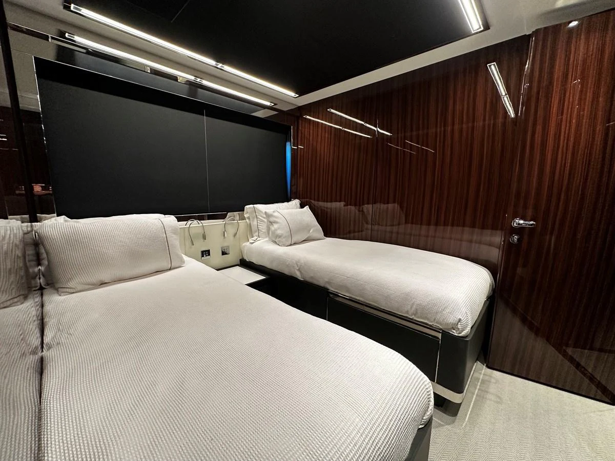 The twin stateroom offers a sleek and modern design with luxurious bedding and high-gloss wood finishes. aboard 4SEAS Yacht for Sale