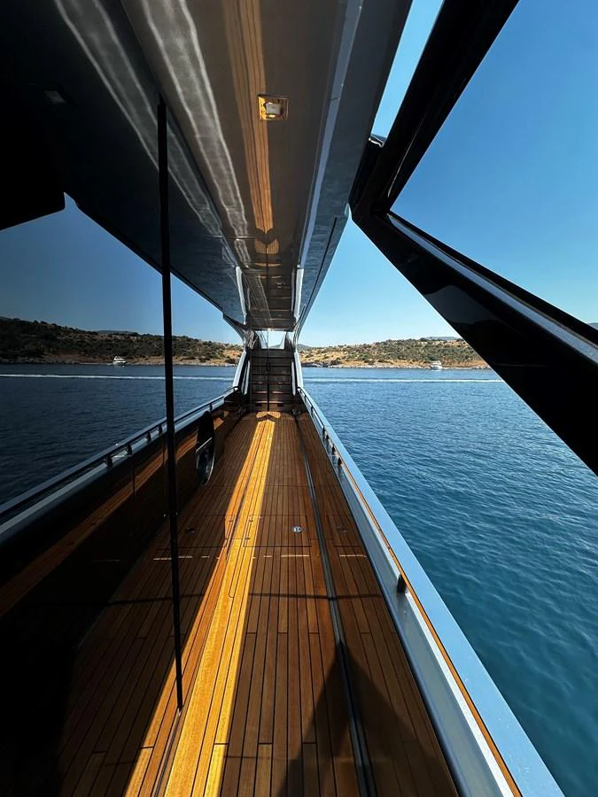 The sleek side deck of the yacht offers a stunning view of the surrounding waters and coastline. aboard 4SEAS Yacht for Sale