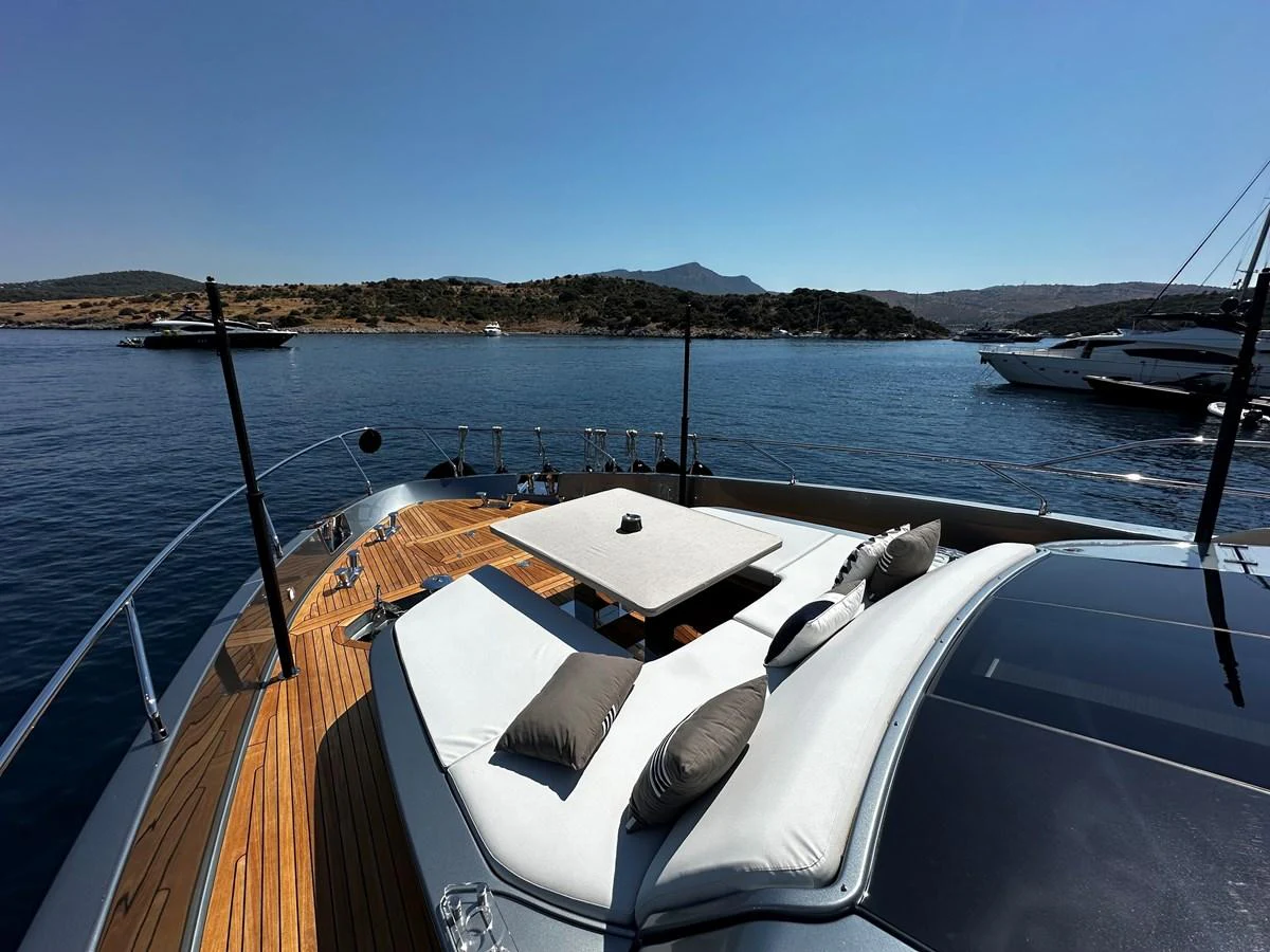 The yacht's foredeck offers a luxurious sunbathing area with plush cushions and a sleek design. aboard 4SEAS Yacht for Sale