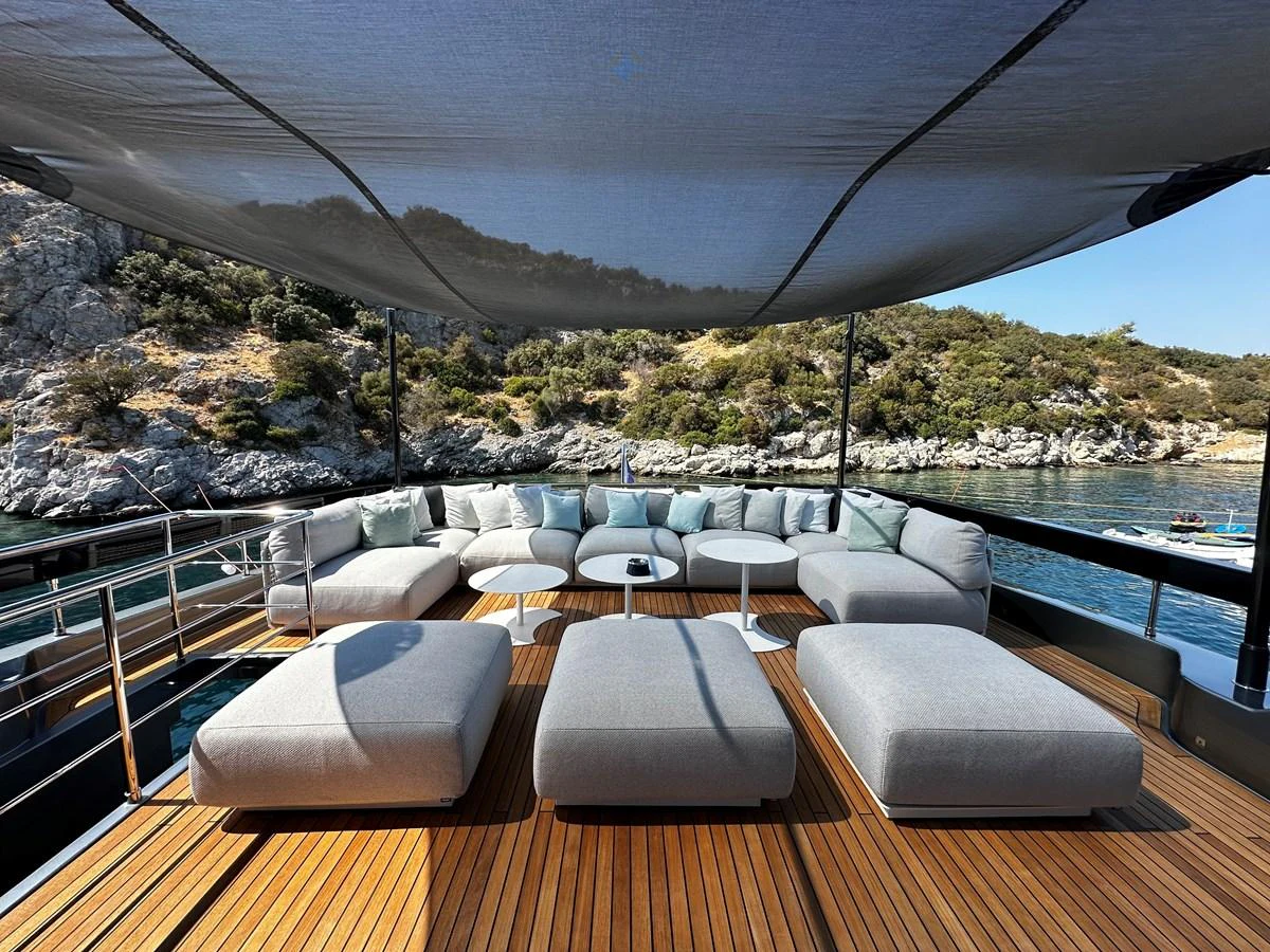 The sundeck features a spacious lounging area with plush seating and a shaded canopy, perfect for relaxation. aboard 4SEAS Yacht for Sale