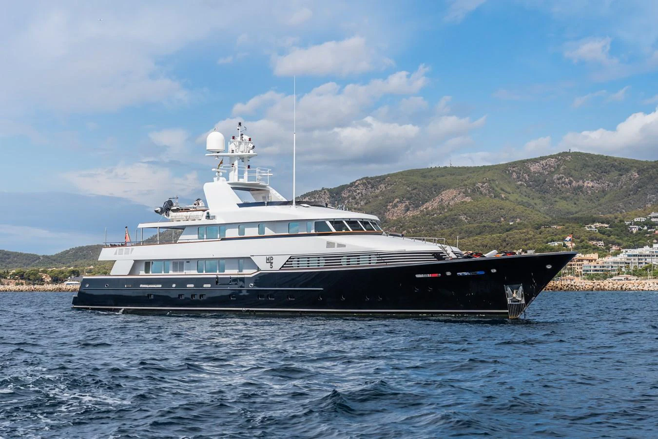 A sleek and elegant yacht cruising on calm waters with a scenic backdrop. aboard MP5 Yacht for Sale