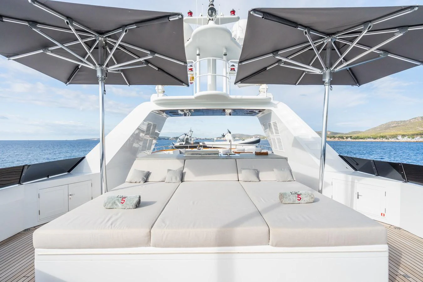 The sundeck features luxurious sunbeds with umbrellas, perfect for relaxation. aboard MP5 Yacht for Sale