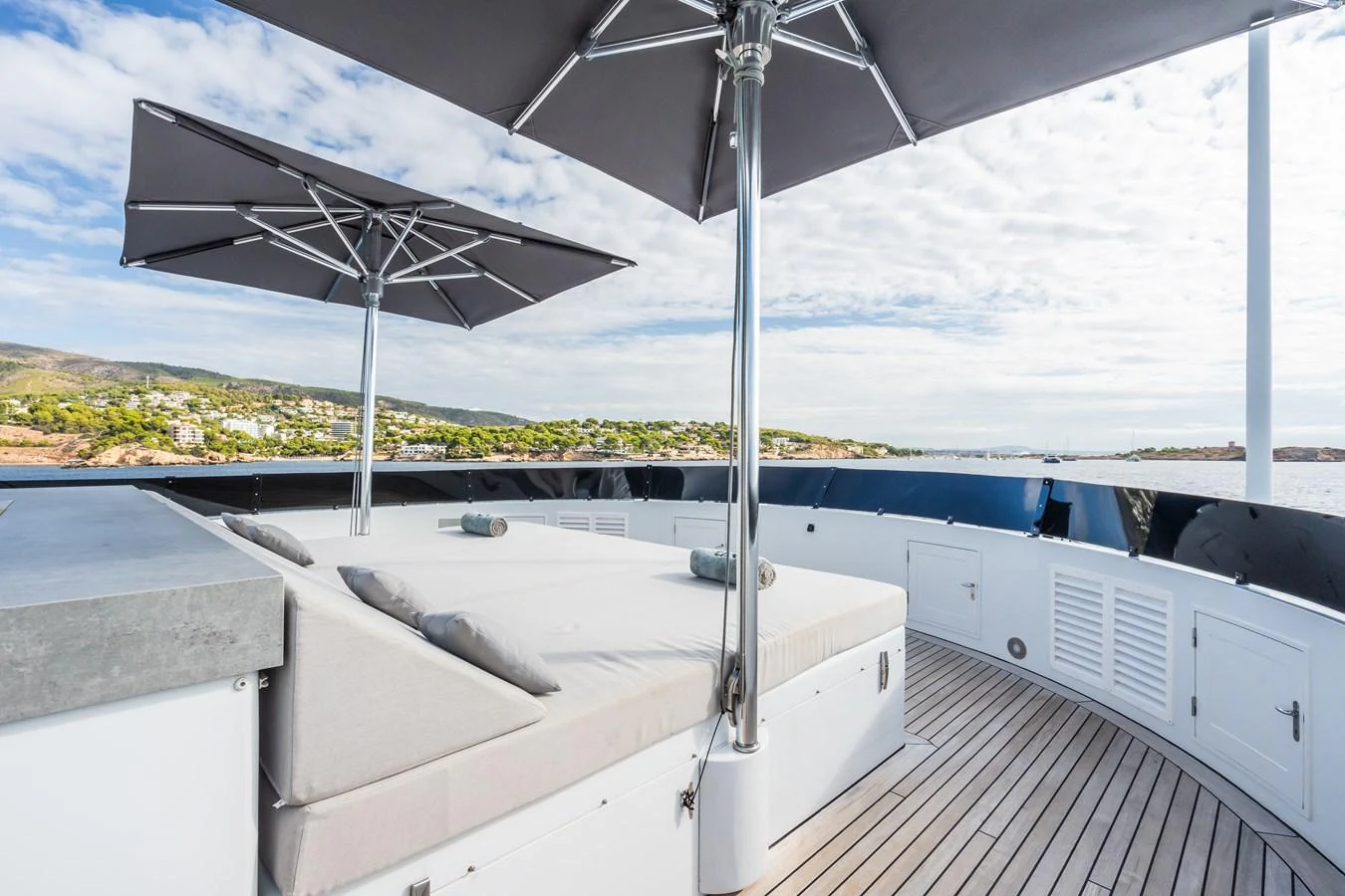 The sundeck features luxurious lounging areas with large umbrellas for shade, offering a perfect spot to relax and enjoy the view. aboard MP5 Yacht for Sale
