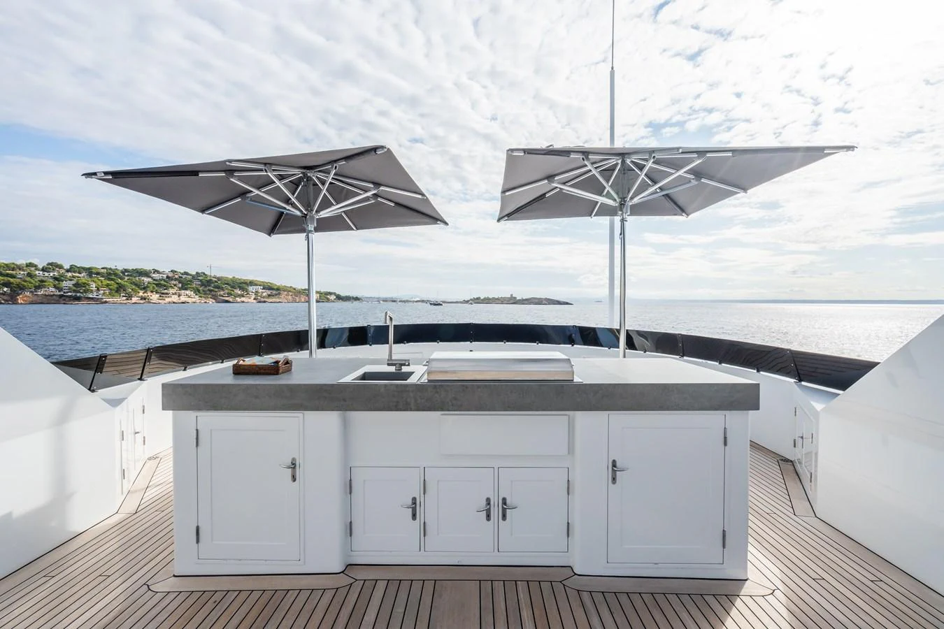The sundeck features a sleek outdoor kitchen with dual umbrellas, perfect for alfresco dining and entertaining. aboard MP5 Yacht for Sale