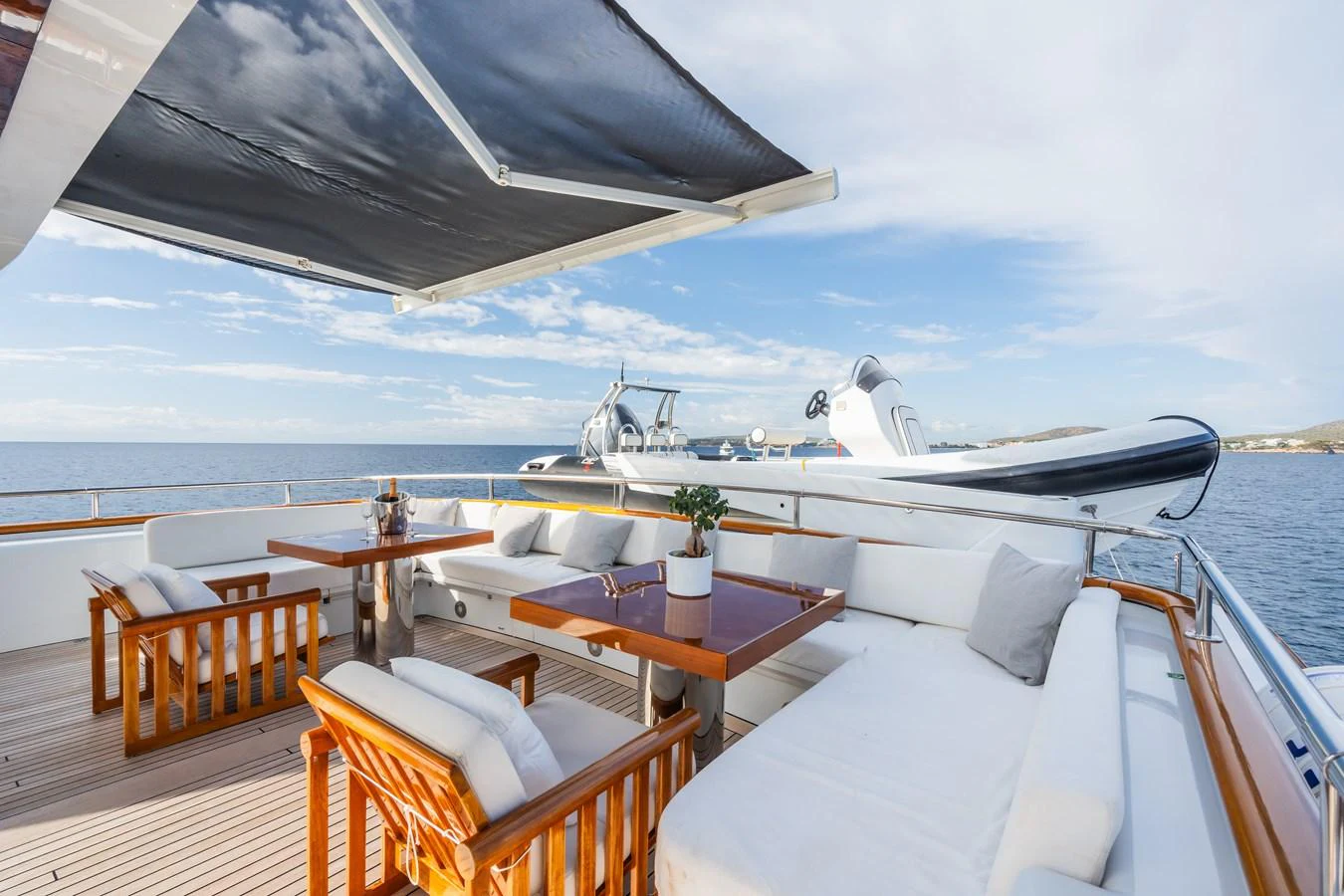 The aft deck features comfortable seating and dining areas with a view of the water. aboard MP5 Yacht for Sale