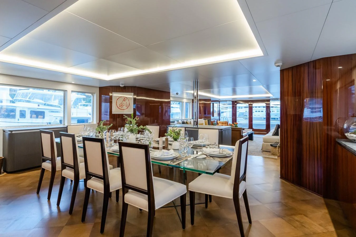 The yacht's dining area features a sophisticated setup with a glass table and elegant seating, complemented by large windows offering scenic views. aboard MP5 Yacht for Sale