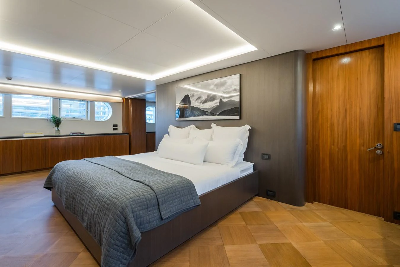 The master stateroom features a luxurious bed with elegant wood paneling and modern lighting. aboard MP5 Yacht for Sale