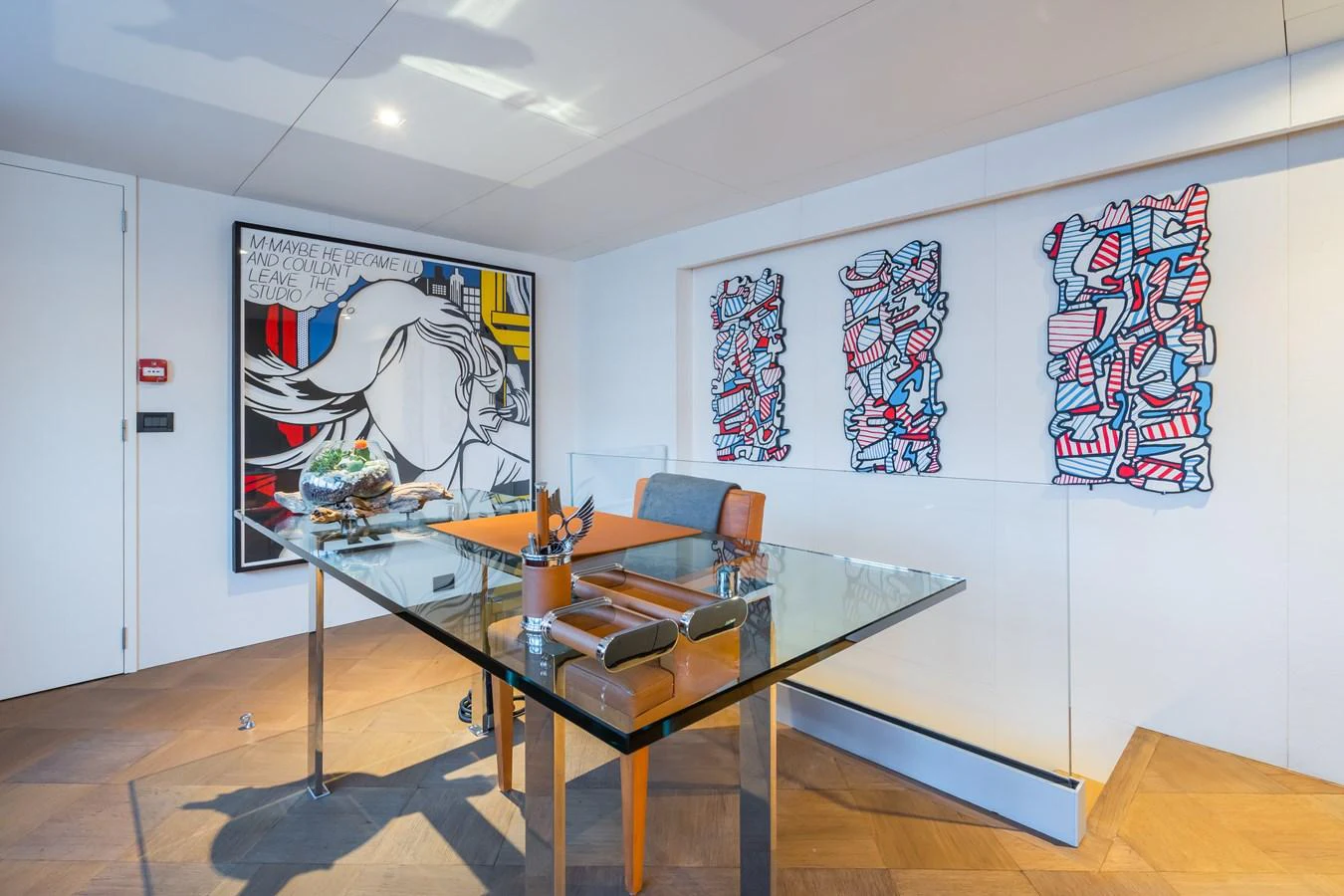 A stylish office space on the yacht, featuring modern art and a sleek glass desk. aboard MP5 Yacht for Sale
