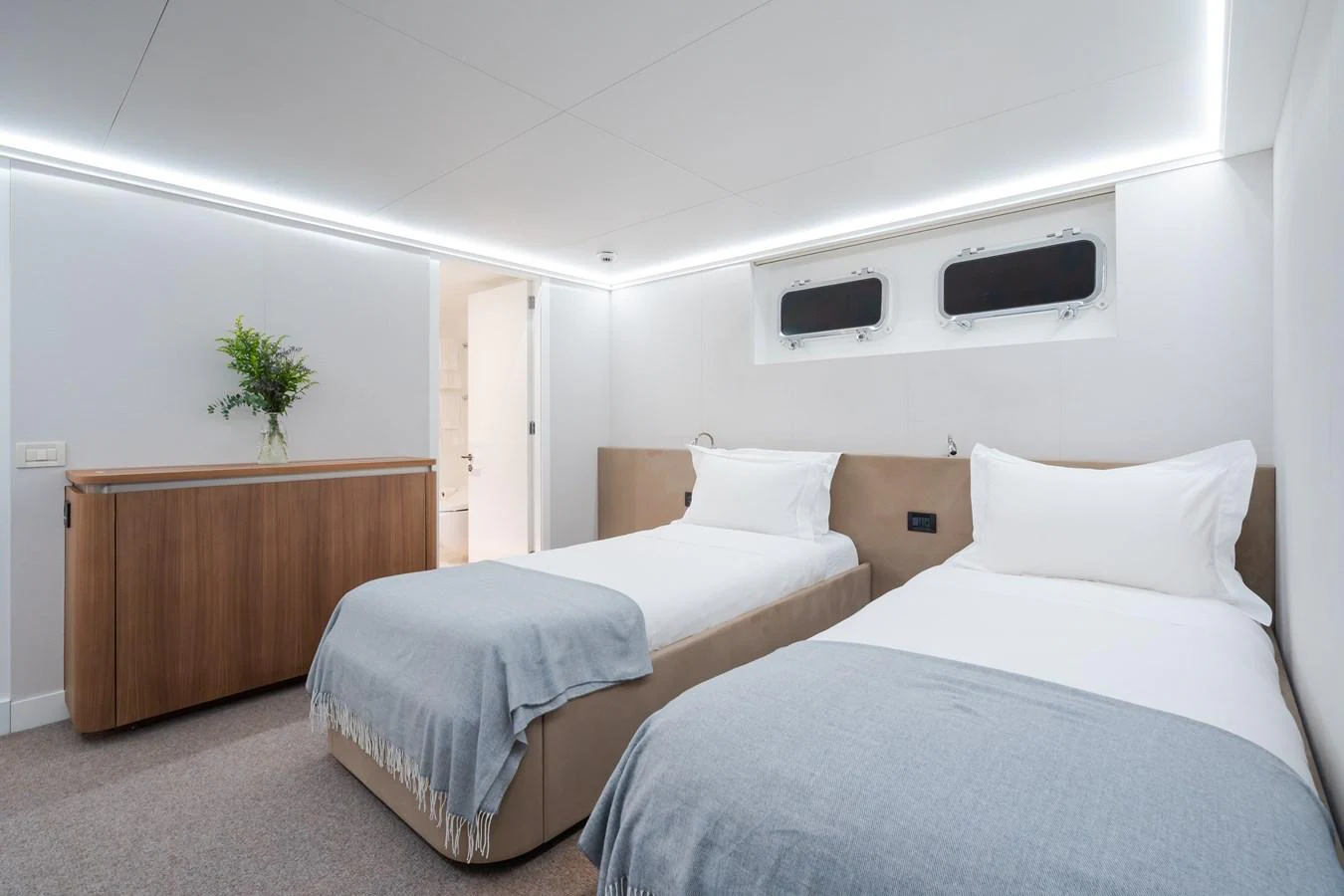 A serene twin stateroom featuring two single beds with soft linens and modern decor. aboard MP5 Yacht for Sale