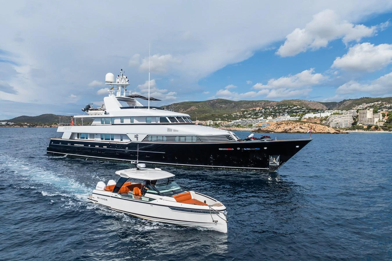 A sleek yacht cruises on the open water with a smaller tender boat accompanying it. aboard MP5 Yacht for Sale