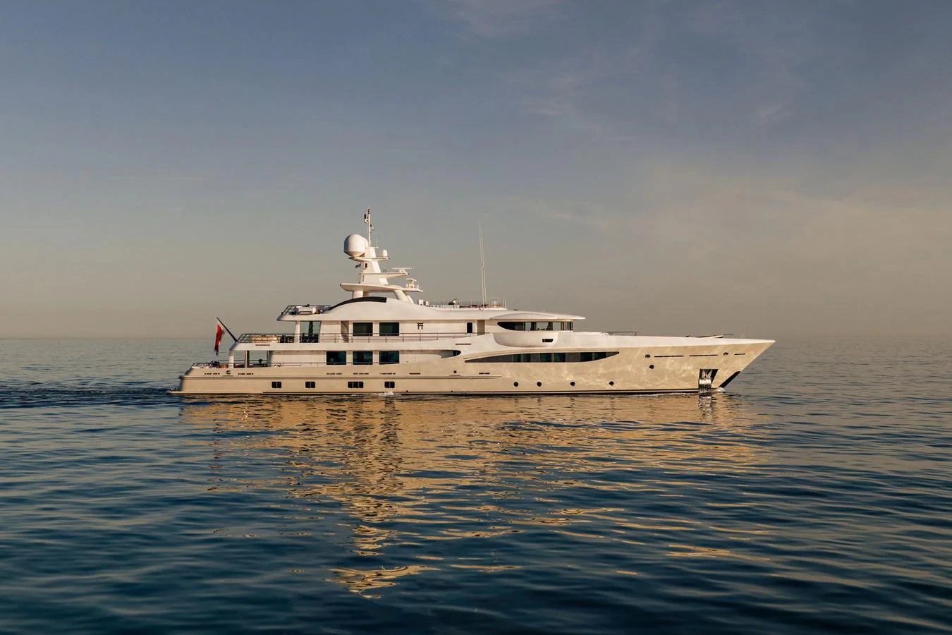 A luxurious yacht glides gracefully across calm waters at sunset. aboard GRACE Yacht for Sale