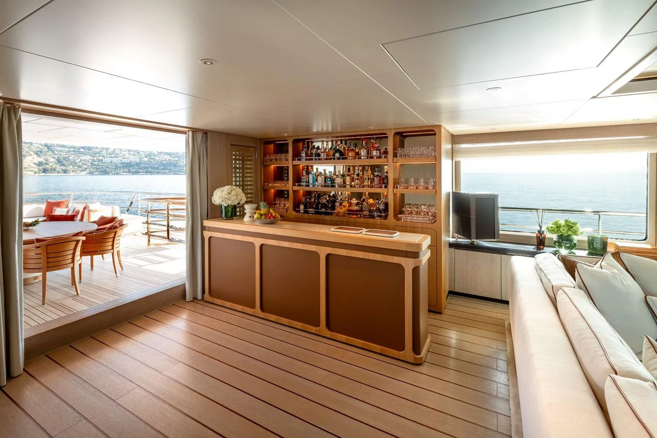 The salon features a stylish bar area with a view of the sea through large windows. aboard GRACE Yacht for Sale