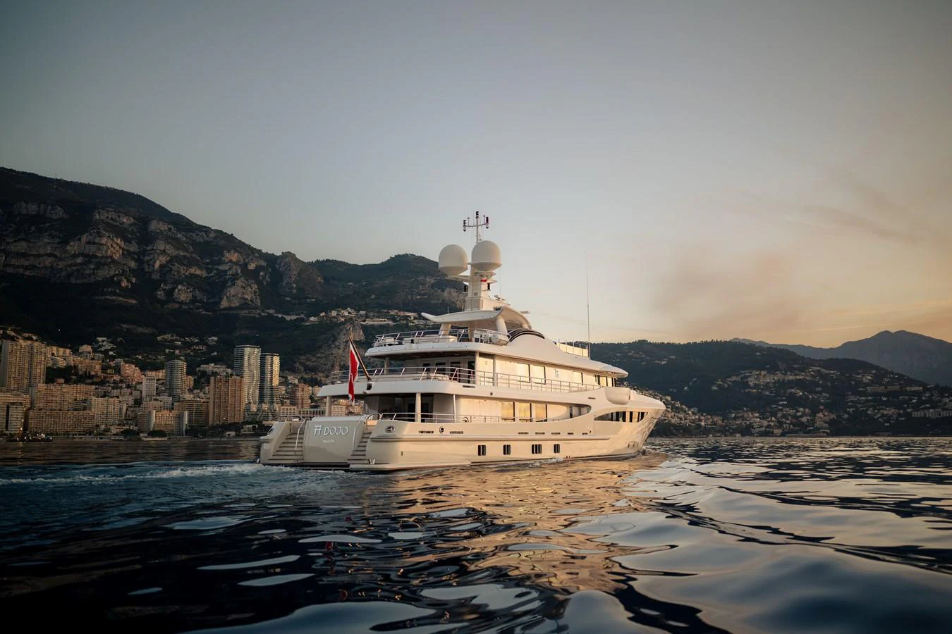 A luxurious yacht cruises gracefully on calm waters against a stunning coastal backdrop. aboard GRACE Yacht for Sale