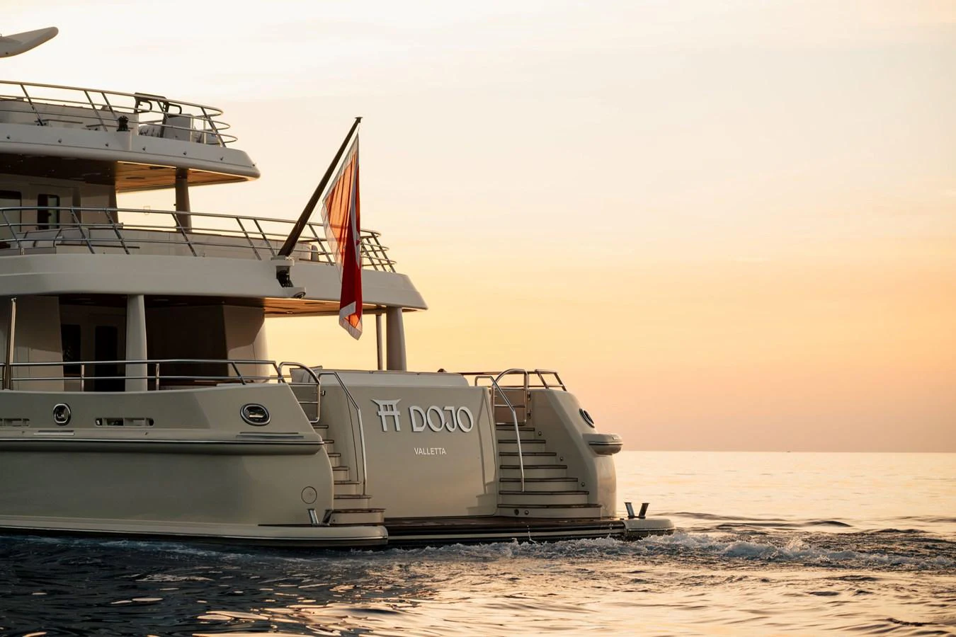 The yacht is captured at sunset, showcasing its elegant stern and flag. aboard GRACE Yacht for Sale