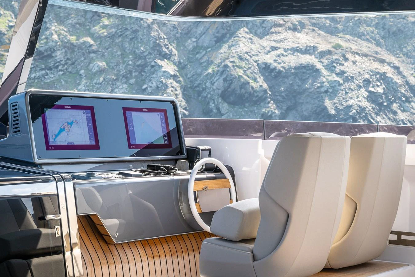 The helm station features modern navigation screens and comfortable seating with a scenic view. aboard FREYA Yacht for Sale