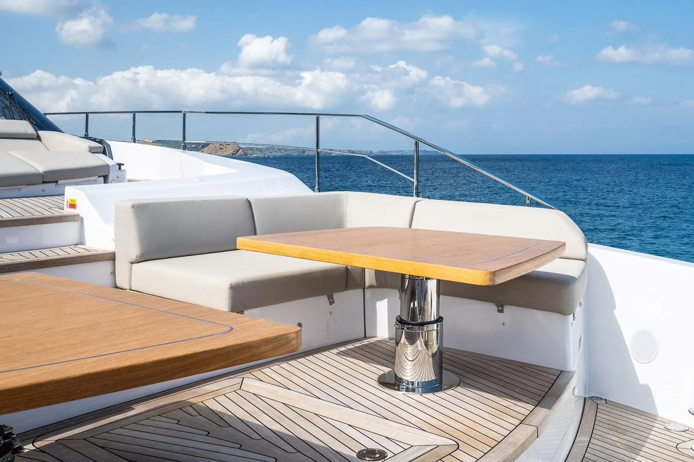 The aft deck features a stylish seating area with a wooden table, perfect for alfresco dining. aboard FREYA Yacht for Sale
