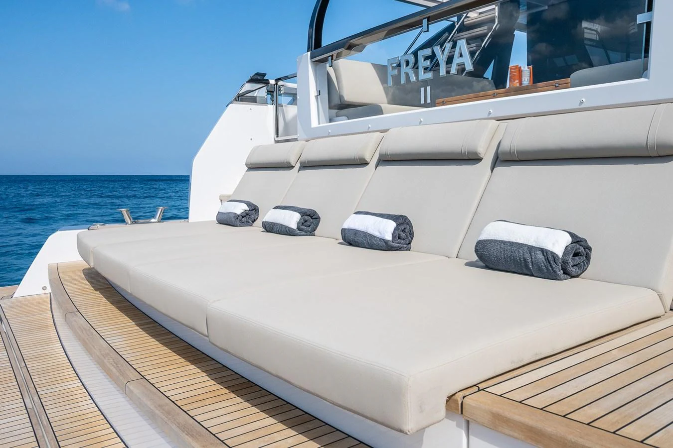 The sundeck features plush sun loungers with rolled towels, perfect for relaxation. aboard FREYA Yacht for Sale