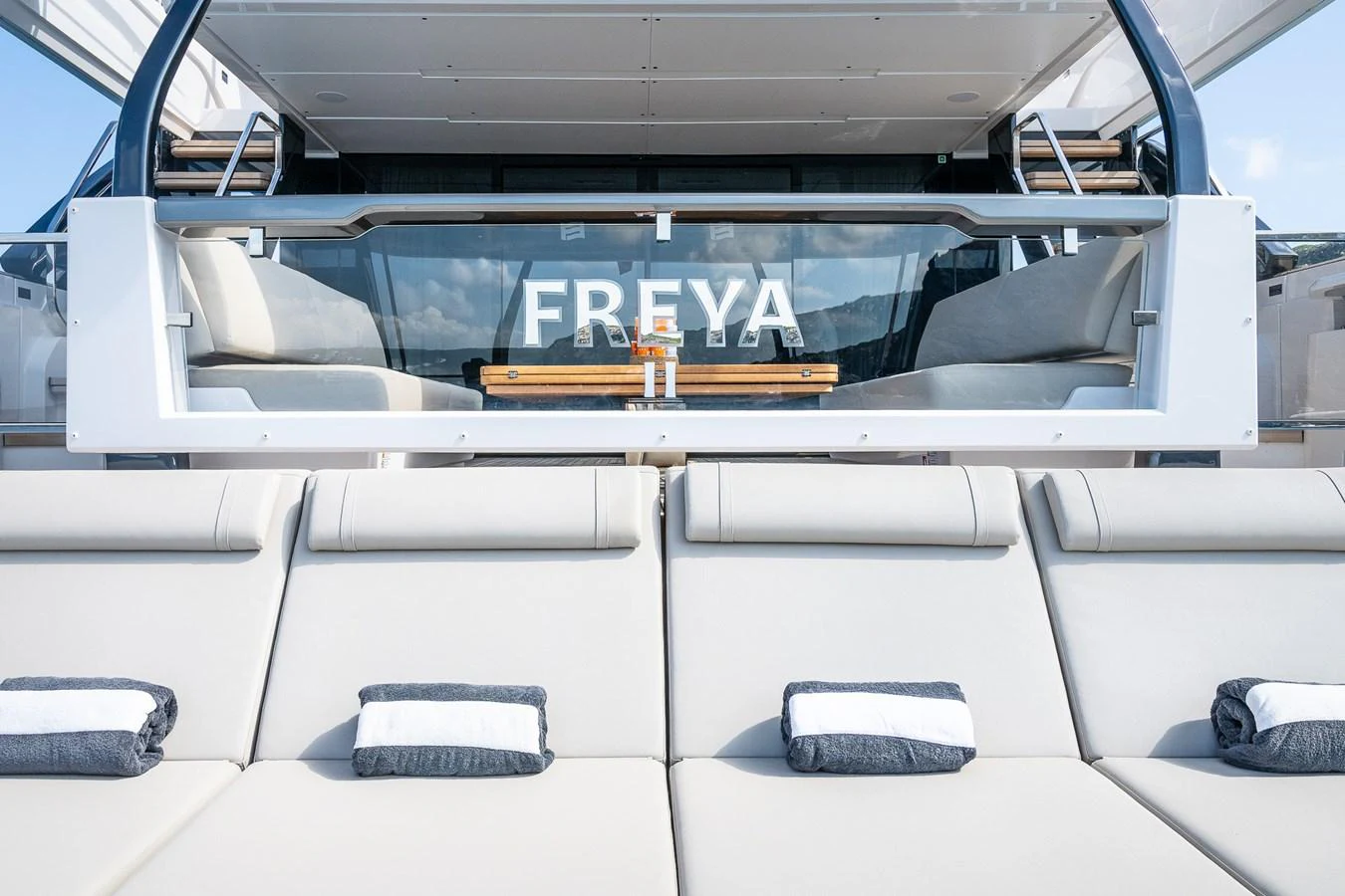 The aft deck features plush sun loungers with neatly arranged towels, perfect for relaxation. aboard FREYA Yacht for Sale