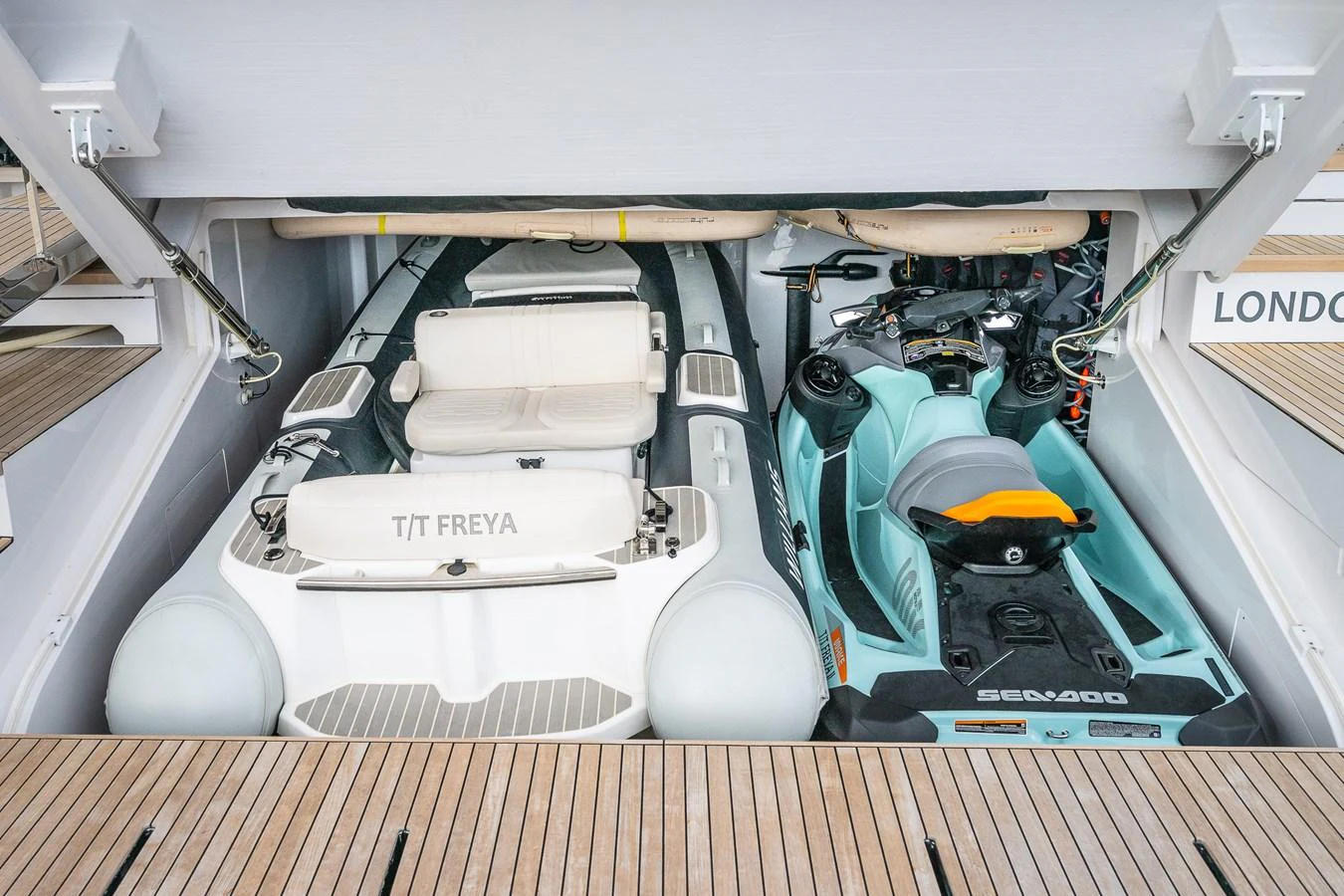 The yacht features a well-organized tender garage with a sleek tender and a personal watercraft. aboard FREYA Yacht for Sale