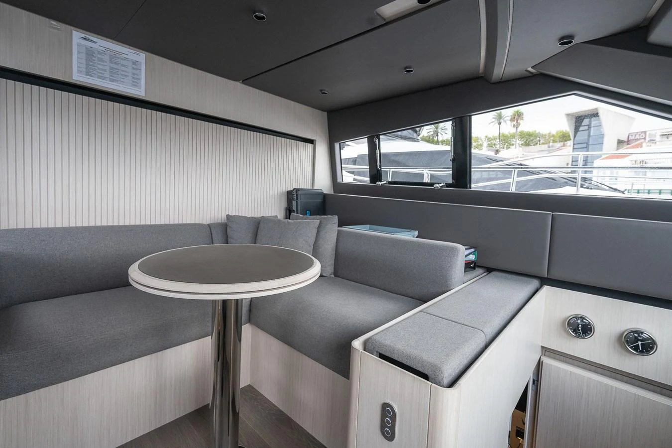 The saloon features a cozy seating area with a modern table and large windows offering plenty of natural light. aboard FREYA Yacht for Sale