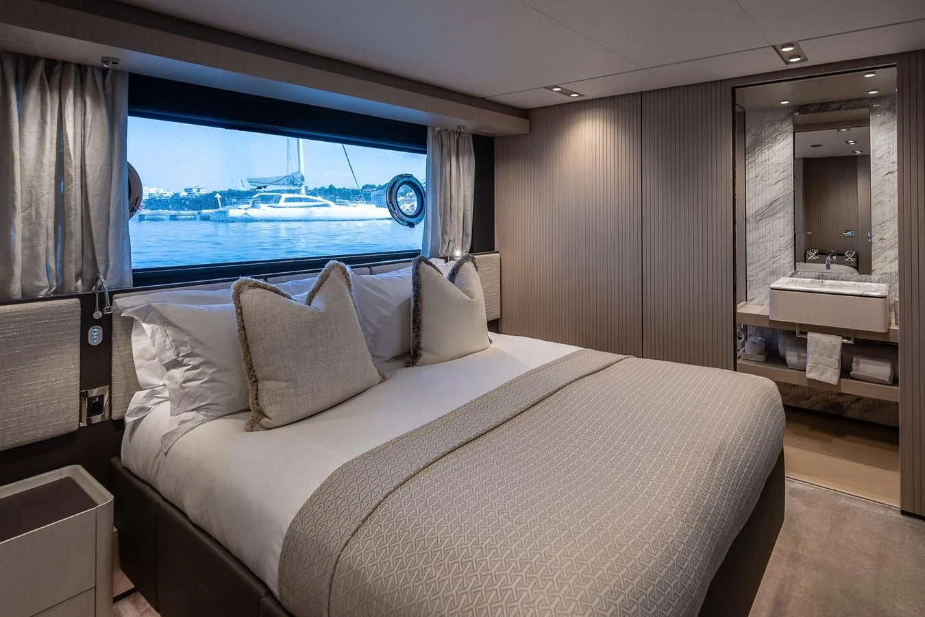 The stateroom features a plush bed with a scenic view through a large window. aboard FREYA Yacht for Sale