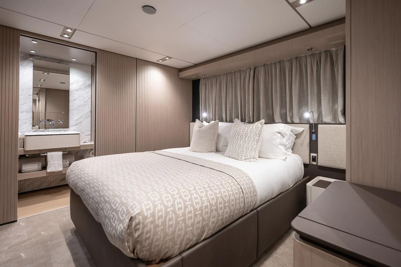 The stateroom features a luxurious bed with elegant bedding and a modern ensuite bathroom. aboard FREYA Yacht for Sale
