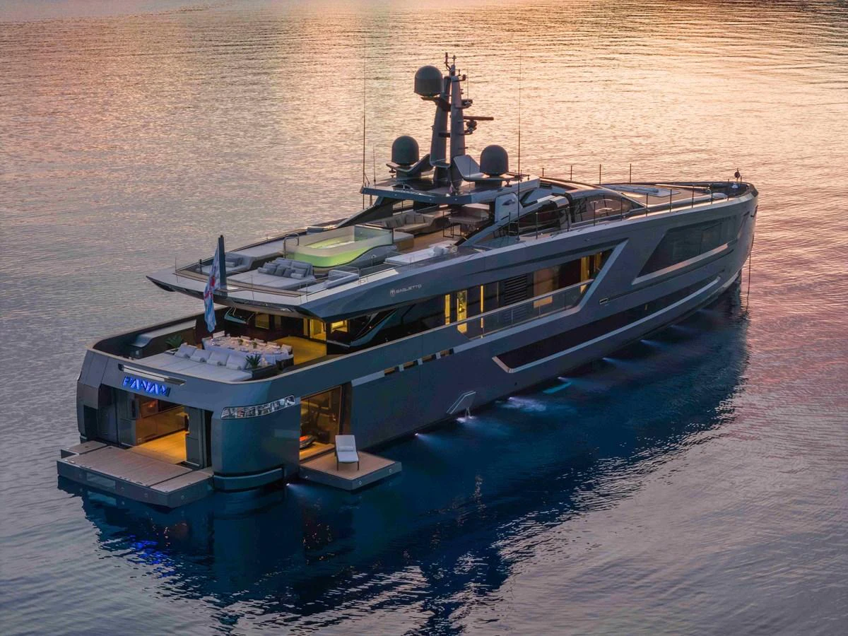 A sleek and modern yacht glides gracefully on calm waters at sunset. aboard PANAM Yacht for Sale