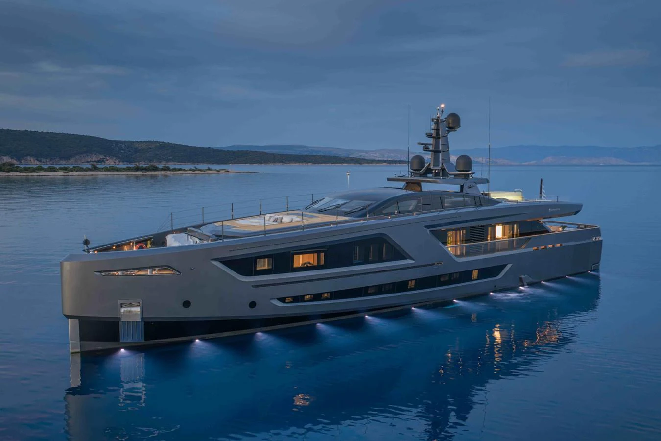 A sleek and modern yacht is anchored in calm waters during twilight. aboard PANAM Yacht for Sale