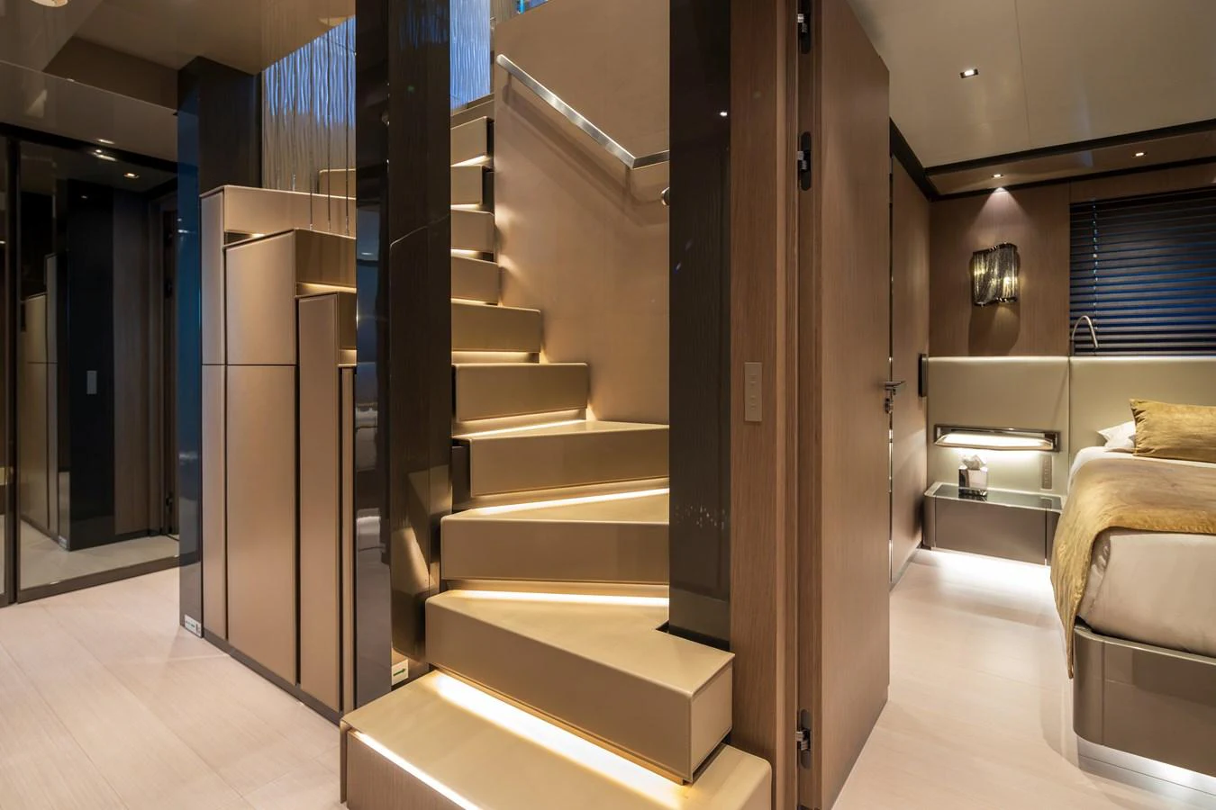 The yacht's interior features a modern staircase with ambient lighting, leading to luxurious living spaces. aboard PANAM Yacht for Sale